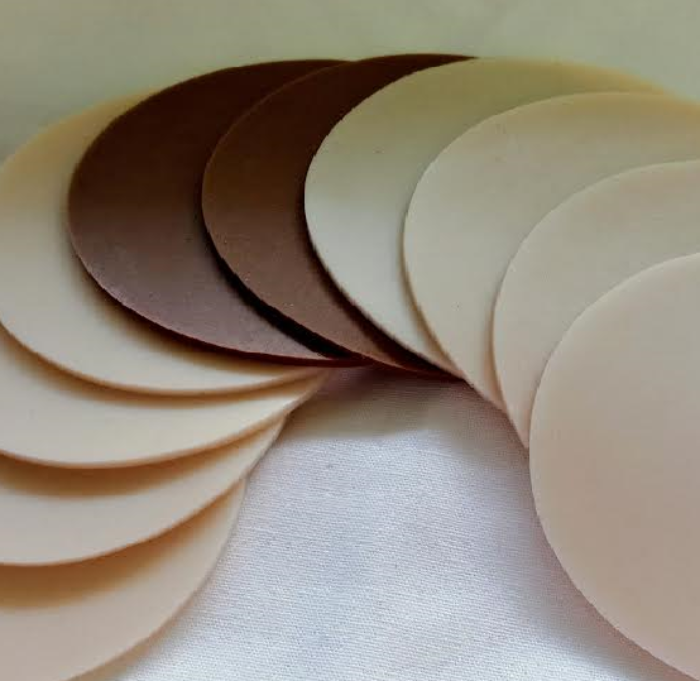 Set of beige adhesive patches arranged in a circular pattern on a light MEDICAL DISCS background